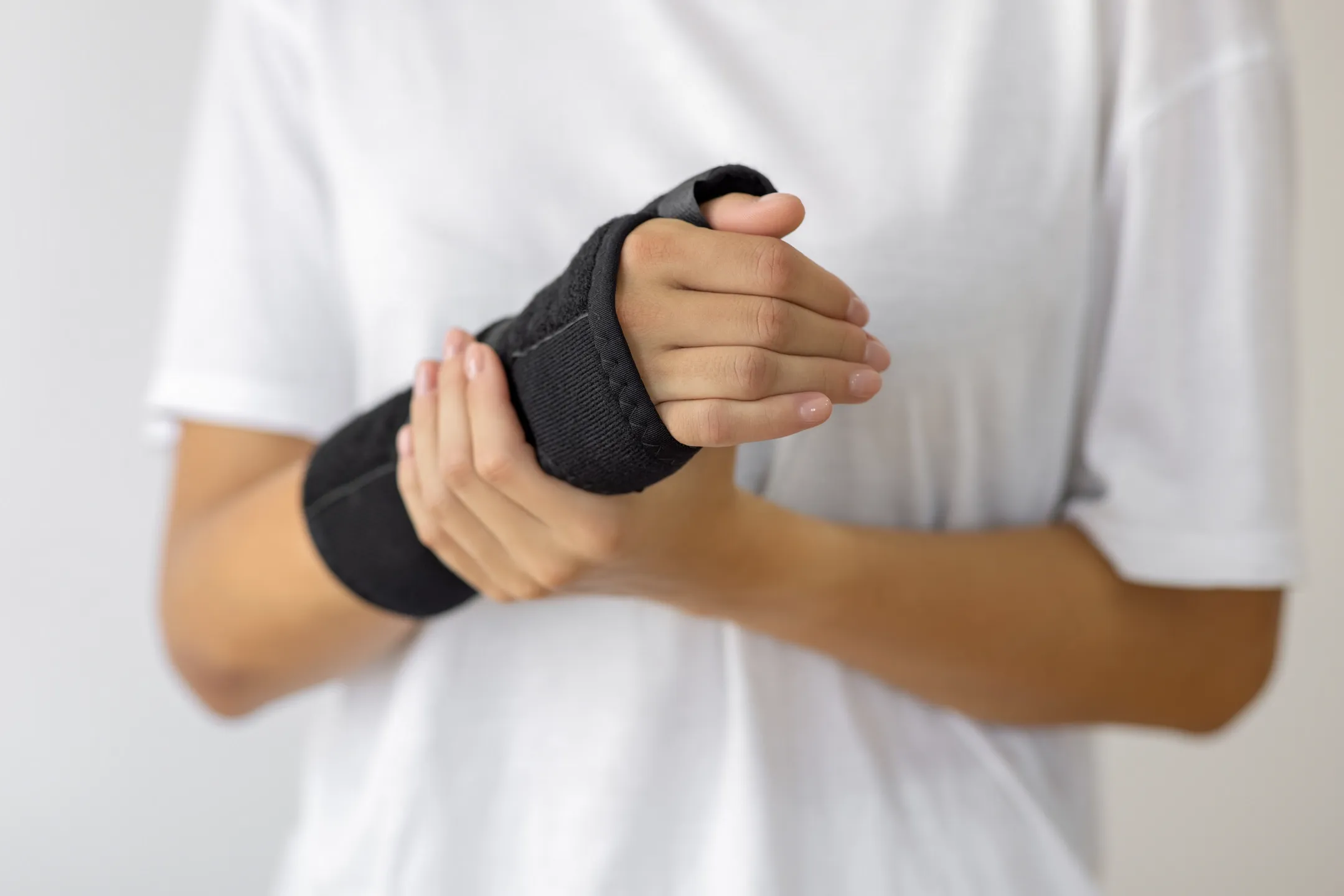 Frau mit verletztem Arm traegt eine Armschiene